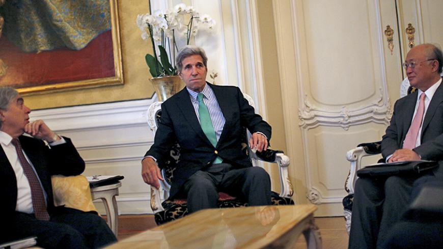 U.S. Secretary of State John Kerry sits between U.S. Secretary of Energy Ernest Moniz (L) and Atomic Energy Agency (IAEA) Director General Yukiya Amano during a meeting at a hotel in Vienna, Austria June 29, 2015. Iran is backtracking from an interim nuclear agreement with world powers three months ago, Western officials suggested on Sunday, as U.S. and Iranian officials said talks on a final accord would likely run past a June 30 deadline.  REUTERS/Carlos Barria - RTX1I8AB