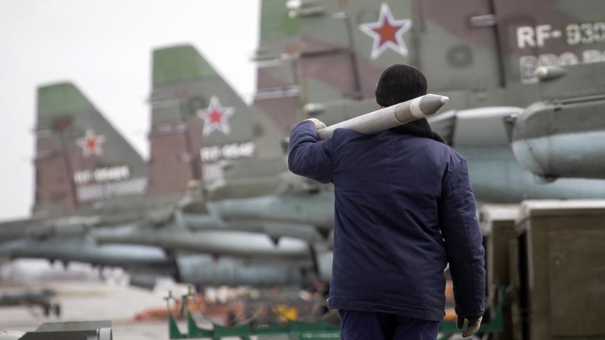 A serviceman carries a air-to-ground missile next to Sukhoi Su-25 jet fighters during a drill at the Russian southern Stavropol region, March 12, 2015.  Russia has started military exercises in the country's south, as well as in Georgia's breakaway regions of South Ossetia and Abkhazia and in Crimea, annexed from Ukraine last year, news agency RIA reported on Thursday, citing Russia's Defence Ministry.  REUTERS/Eduard Korniyenko  (RUSSIA - Tags: POLITICS CIVIL UNREST MILITARY) - RTR4T425