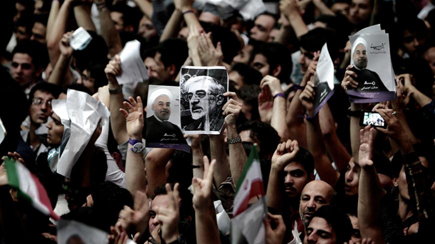 A supporter of Iranian former Vice-President Mohammad Reza Aref, holds a portrait of opposition leader Mir Hossein Mousavi who is under the house arrest since February 2011, during a campaign rally for Aref in Tehran on June 10, 2013. AFP PHOTO/BEHROUZ MEHRI        (Photo credit should read BEHROUZ MEHRI/AFP/Getty Images)