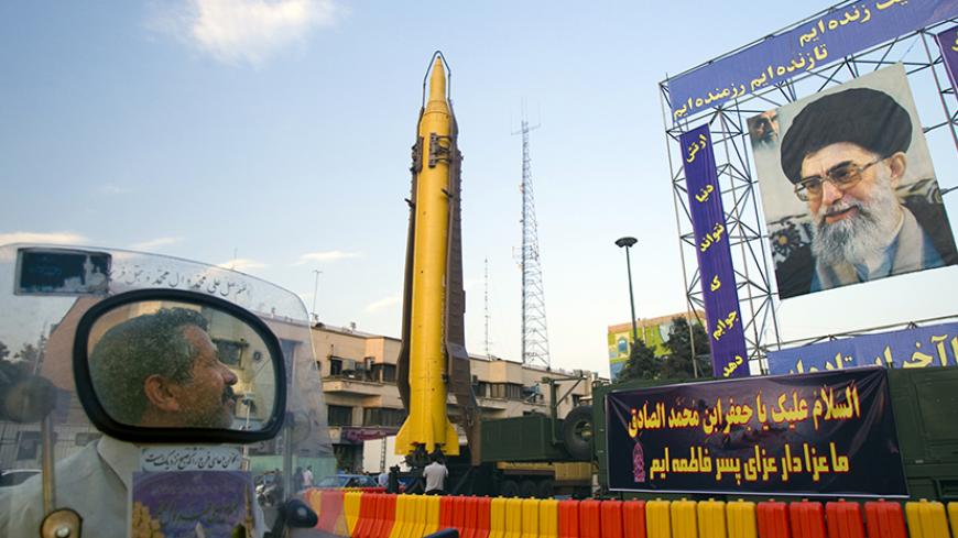 EDITORS' NOTE: Reuters and other foreign media are subject to Iranian restrictions on their ability to film or take pictures in Tehran.
A motorcyclist looks at an Iranian-made Ghadr-F missile during a war exhibition held by Iran's revolutionary guard to mark the anniversary of the Iran-Iraq war (1980-88), also known in Iran as the "Holy Defence", at Baharestan square near the Iranian Parliament in southern Tehran September 23, 2011. A portrait of Iran's Supreme Leader Ayatollah Ali Khamenei is seen on right