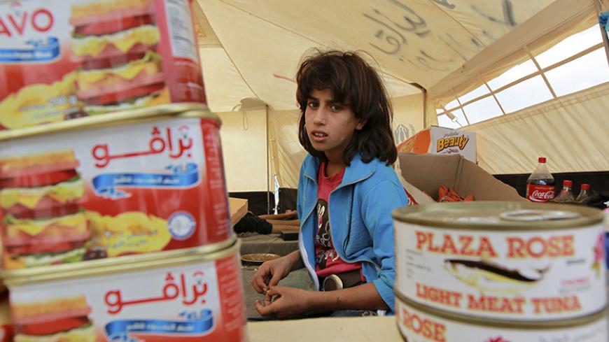 A Syrian child refugee sells canned food and snacks in her small grocery shop in front of her tent, at the Al Zaatri refugee camp, in the Jordanian city of Mafraq, near the border with Syria, October 4, 2012. REUTERS/Muhammad Hamed (JORDAN - Tags: POLITICS CIVIL UNREST) - RTR38SAK