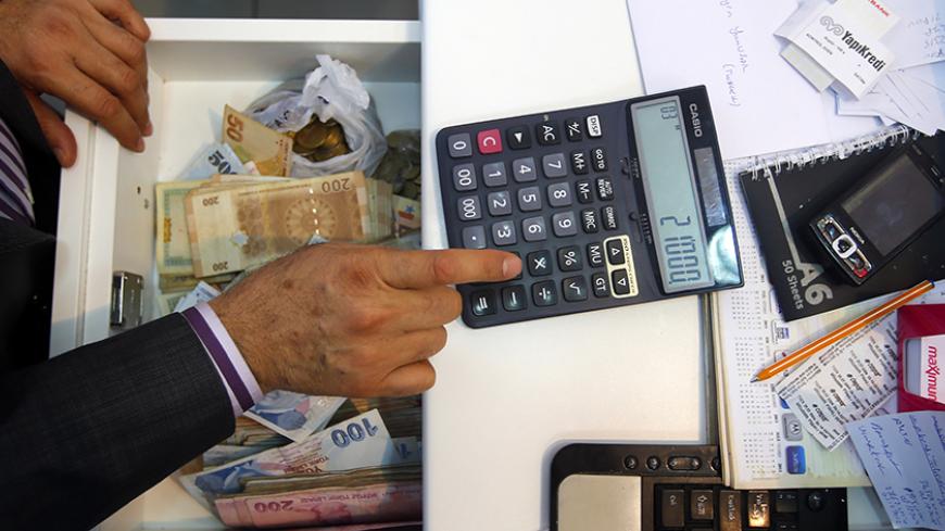 A money changer calculates the exchange rate of Turkish lira to Syrian pound at his office in the southern Turkish town of Reyhanli November 29,2012.  REUTERS/Laszlo Balogh (TURKEY - Tags: BUSINESS POLITICS) - RTR3B0WS