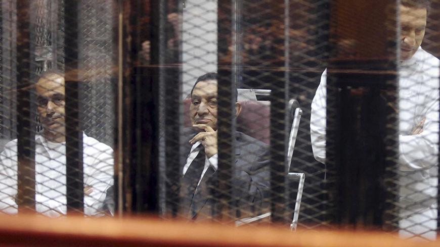 Egypt's ousted President Hosni Mubarak sits next to his sons Gamal (L) and Alaa (R) inside a dock at the police academy on the outskirts of Cairo May 21, 2014. An Egyptian court on Wednesday sentenced Hosni Mubarak to three years in prison on charges of stealing public funds. His sons were sentenced to four years in jail on the same charges. REUTERS/Stringer (EGYPT - Tags: POLITICS CIVIL UNREST CRIME LAW) - RTR3Q5QZ