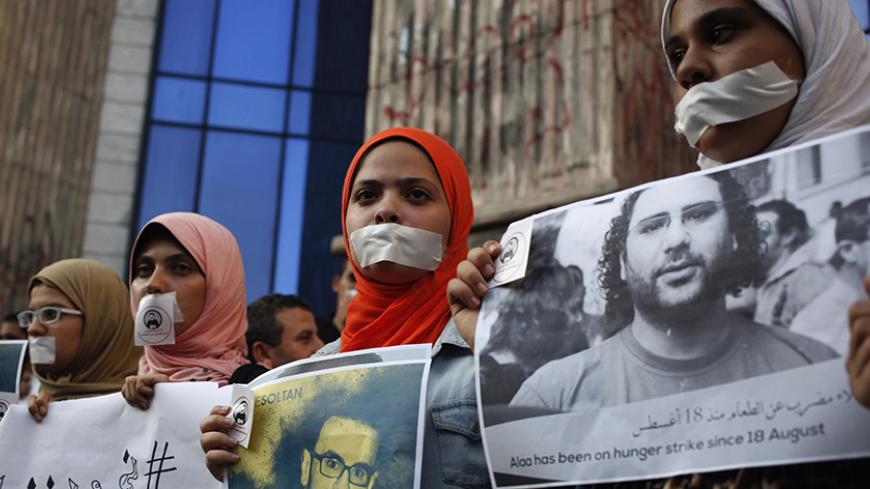 Protesters hold pictures during a protest in support of imprisoned activists who are in a hunger strike at prison, in front of the Press Syndicate, in Cairo August 25, 2014. REUTERS/Asmaa Waguih (EGYPT - Tags: POLITICS CIVIL UNREST MEDIA) - RTR43OK4