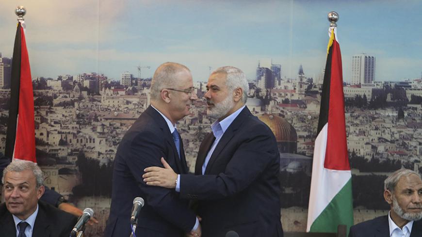 Senior Hamas leader Ismail Haniyeh (R) shakes hands with Palestinian Prime Minister Rami Hamdallah at Haniyeh's house in Gaza City October 9, 2014. Hamdallah arrived in the Hamas-dominated Gaza Strip on Thursday and convened the first meeting of a unity government there since a brief civil war in 2007 between Hamas and forces loyal to the Fatah party.    REUTERS/Ibraheem Abu Mustafa (GAZA - Tags: POLITICS CIVIL UNREST) - RTR49J7M