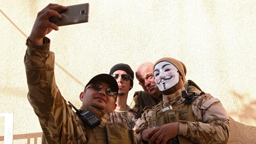 Westerners who have joined the Iraqi Christian militia Dwekh Nawsha to fight against Islamic State militants, take a photograph together at the office of the Assyrian political party in Dohuk, northern Iraq February 13, 2015. Thousands of foreigners have flocked to Iraq and Syria in the past two years, mostly to join Islamic State, but a handful of idealistic Westerners are enlisting as well, citing frustration their governments are not doing more to combat the ultra-radical Islamists or prevent the sufferi