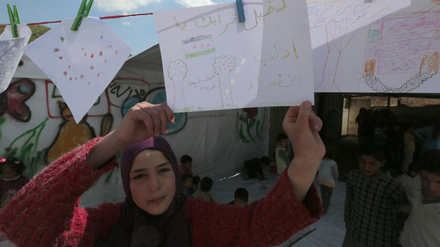 A Syrian girl displays a drawing hanging at a makeshift settlement for Syrian refugees in Bar Elias, in the Bekaa valley, March 15, 2015. March 15 marks the fourth anniversary of peaceful protests against Syrian President Bashar al-Assad, leading to the devastating civil conflict in the country. Britain-based Syrian Observatory for Human Rights said more than 215,000 people have been killed since the start of the crisis in 2011, around half of them civilians. REUTERS/Jamal Saidi (LEBANON - Tags: CIVIL UNRES
