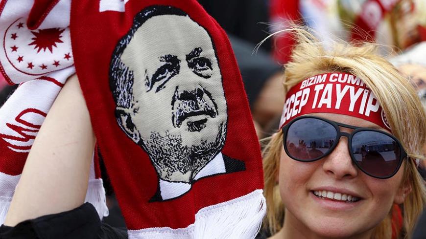 A supporter of Turkish President Tayyip Erdogan waves a scarf with an image of the president during a ceremony to mark the 562nd anniversary of the conquest of the city by Ottoman Turks, in Istanbul, Turkey, May 30, 2015. REUTERS/Murad Sezer  - RTR4Y6BU