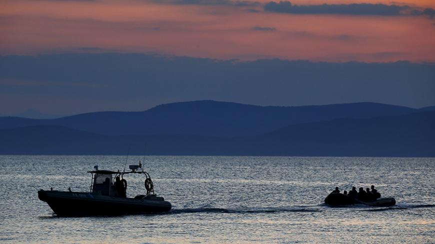 A dinghy (R) with Syrian refugees is towed by a Greek coast guard patrol boat into the port on the Greek island of Kos, following a rescue operation in a part of the Aegean Sea between Turkey and Greece, early May 31, 2015. According to local media, an average of over 200 immigrants on small dinghies have been arriving in Kos every day in the last two months. REUTERS/Yannis Behrakis - RTR4Y74I