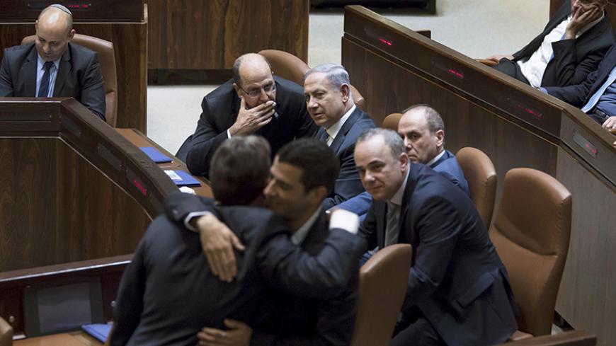 Israeli Prime Minister Benjamin Netanyahu (C) sits next to his Defense Minister Moshe Ya'alon (L) during a swearing-in ceremony at the Knesset, the Israeli parliament, in Jerusalem May 14, 2015. Netanyahu's new rightist coalition government, hobbled from the outset by its razor-thin parliamentary majority, was sworn in late on Thursday amid wrangling within his Likud party over cabinet posts. Picture taken May 14, 2015. REUETRS/Jim Hollander/Pool - RTX1D2SJ