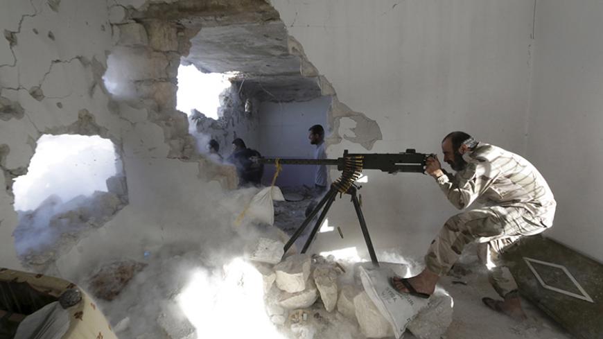 A Free Syrian Army fighter fires a weapon inside a damaged building during clashes with forces loyal to Syria's President Bashar al-Assad at the frontline in Handarat area, north of Aleppo May 21, 2015. REUTERS/Hosam Katan       TPX IMAGES OF THE DAY      - RTX1E0J0