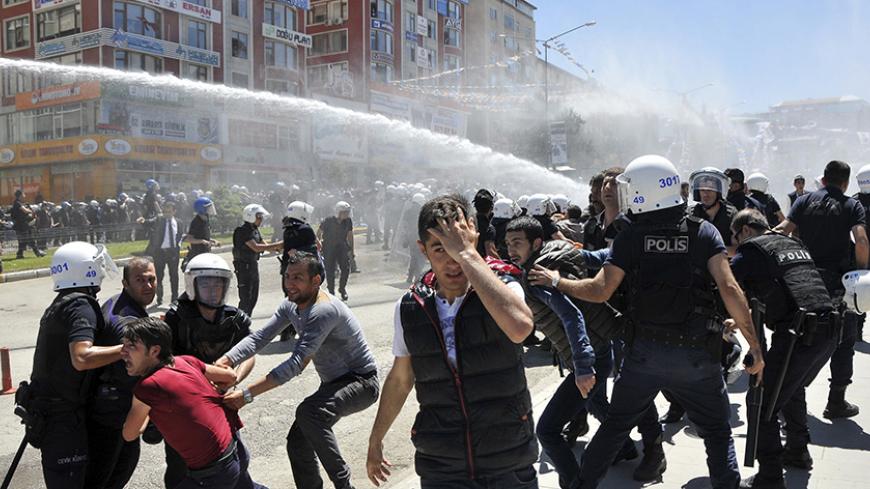 Riot police try to stop protesters in the eastern city of Erzurum, Turkey, June 4, 2015. Turkish police fired tear gas and water cannon to disperse crowds protesting against a rally by the pro-Kurdish Peoples' Democratic Party (HDP) in eastern Turkey on Thursday, ahead of weekend parliamentary elections. The clashes are the latest in a series of incidents to mar campaigning in the run-up to Sunday's highly charged vote, in which the HDP is hoping to deal a heavy blow to President Tayyip Erdogan's hopes of a