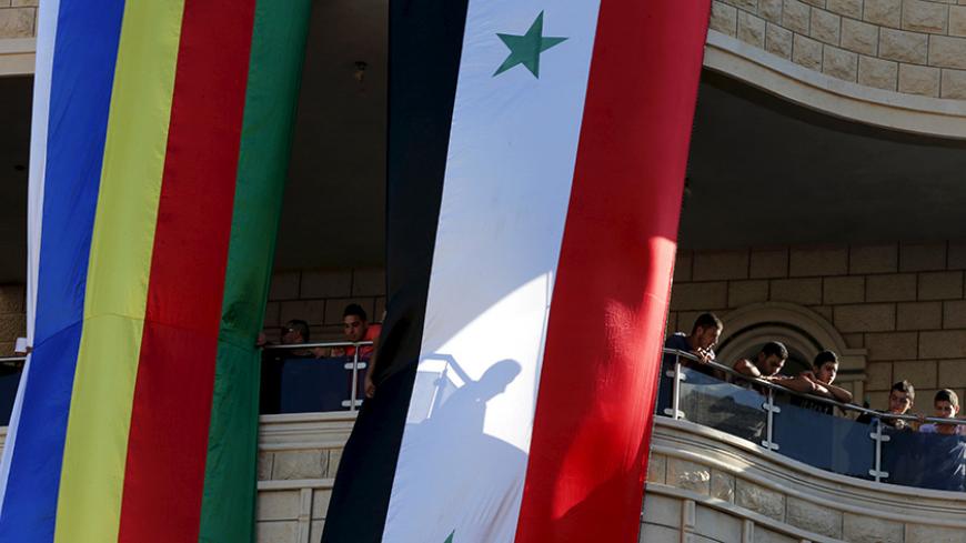 Members of the Druze community stand behind Syrian (R) and Druze flags during a protest in the Druze village of Majdal Shams on the Golan Heights, June 15, 2015. Several hundred members of the Druze community on Monday called on Syrian President Bashar al-Assad to protect their Syrian kin following last week's killing of 20 Druze villagers by the Nusra Front, Syria's al Qaeda branch, during fighting in the ongoing Syrian civil war. Israel captured the Golan Heights from Syria in the 1967 Middle East war and