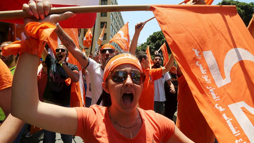 Supporters of the Free Patriotic Movement (FPM) carry flags during a protest in Beirut, Lebanon July 9, 2015. Hundreds of supporters of a Lebanese Christian politician protested in Beirut on Thursday against the Sunni prime minister they claim is marginalizing Christian influence, stirring tensions in a country in crisis over war in neighboring Syria. Michel Aoun accuses Prime Minister Tammam Salam of taking decisions without cross-party consensus and usurping powers reserved for the president - a post set 