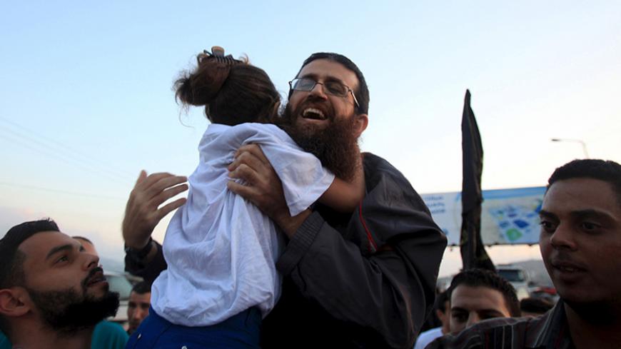 Islamic Jihad leader, Khader Adnan is hugged by his daughter upon his release from an Israeli jail, in the West Bank village of Arabeh near Jenin July 12, 2015. Israel on Sunday released Adnan from jail following a deal last month in which he agreed to end a 56-day hunger strike, Islamic Jihad sources in the West Bank said. REUTERS/Stringer       TPX IMAGES OF THE DAY      - RTX1K24O