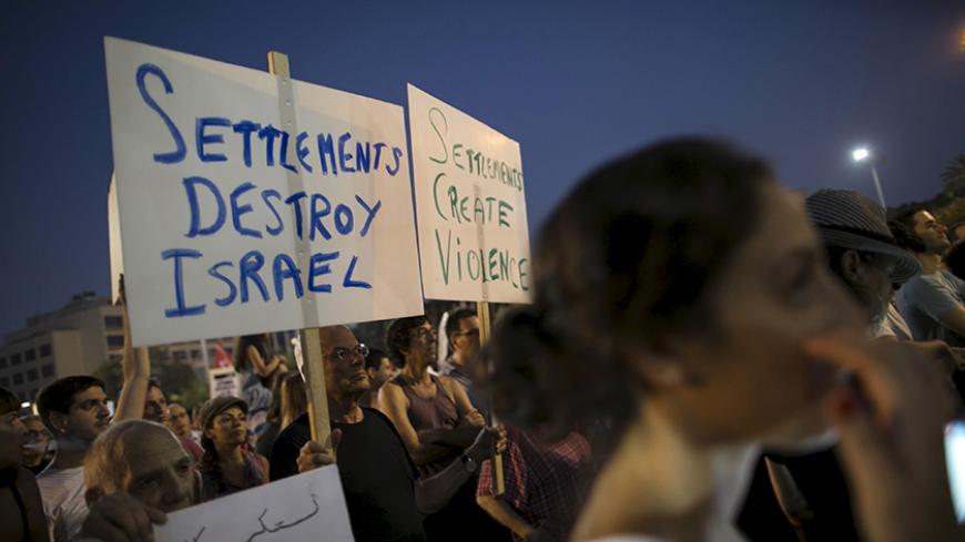 Left-wing protesters write slogans on signs before a protest condemning Friday's arson attack in the West Bank, at Rabin square in Tel Aviv August 1, 2015. Some 3,000 demonstrators gathered for the rally organised by the Israeli anti-settler group Peace Now against the attack by suspected Jewish assailants who torched a Palestinian home in the occupied West Bank on Friday, killing an 18-month-old toddler and seriously injuring three other family members, an act that Israel's prime minister described as terr