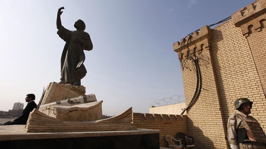 An Iraqi soldier stands guard below the Statue of Mutanabbi, a 10th century poet and one of the towering figures of Arabic literature, on the banks of the Tigris River in Baghdad December 16, 2011. REUTERS/Thaier al-Sudani (IRAQ - Tags: SOCIETY MILITARY) - RTR2VBFQ
