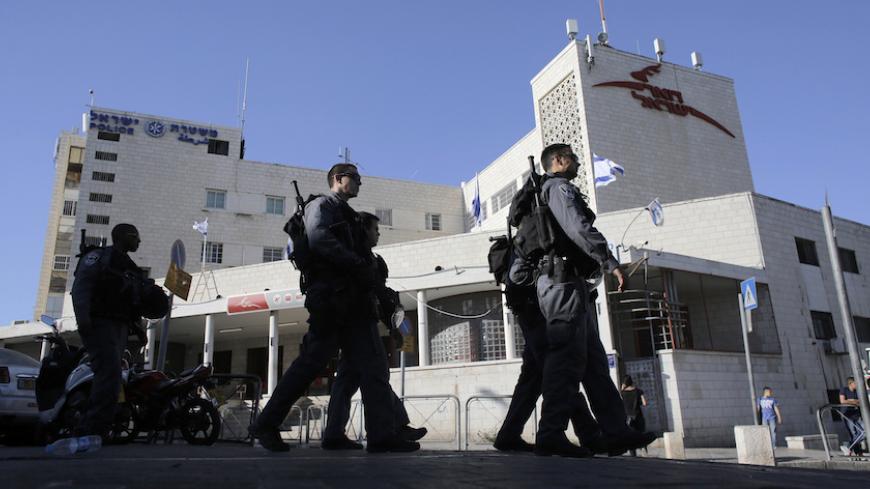 Israeli police officers walk past a post office building in East Jerusalem April 29, 2014. A Jewish seminary, in a bustling commercial area in the same building as a post office serving thousands of Palestinians every day, is the first Jewish housing venture on Saladin Street, a main shopping thoroughfare across from the walled Old City. Palestinians and Israeli critics worry the placement of the academy in such a central location is asking for trouble in East Jerusalem, which has stayed largely trouble-fre
