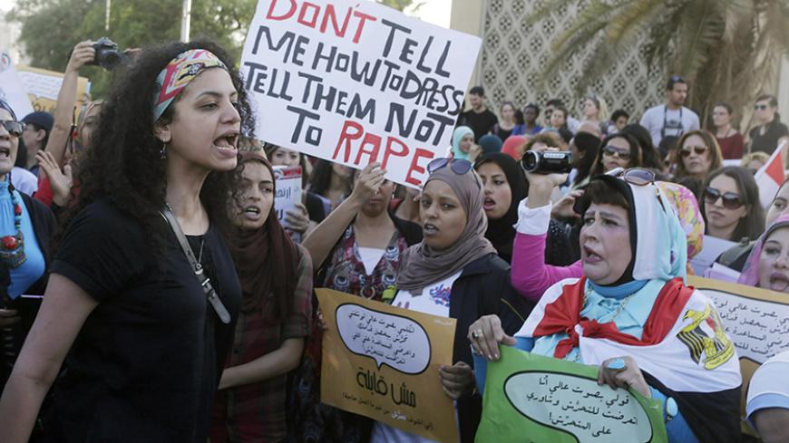 Women chant slogans as they gather to protest against sexual harassment in front of the opera house in Cairo June 14, 2014, after a woman was sexually assaulted by a mob during the June 8 celebrations marking the new president Abdel Fattah al-Sisi's inauguration in Tahrir square. Egypt has asked YouTube to remove a video showing the naked woman with injuries being dragged through the square after being sexually assaulted during the celebrations. Authorities have arrested seven men aged between 15 and 49 for