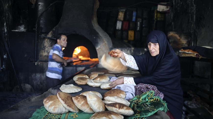 A Palestinian bakes bread in a clay oven in Khan Younis in the southern Gaza Strip July 27, 2014. Fighting subsided in Gaza on Sunday after Hamas Islamist militants said they backed a 24-hour humanitarian truce, but there was no sign of any comprehensive deal to end their conflict with Israel.  REUTERS/Ibraheem Abu Mustafa (GAZA - Tags: SOCIETY) - RTR40AIF