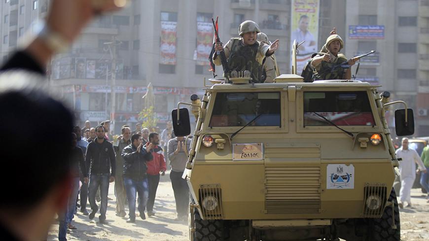 Army soldiers take their positions with their armoured personnel vehicles during clashes with supporters of Muslim Brotherhood and ousted Egyptian President Mohamed Mursi in the Cairo suburb of Matariya November 28, 2014. Two people including an army general were killed and 25 were wounded on Friday in a drive-by shooting and clashes that erupted during Islamist protests around Egypt called by hardline Salafi group, the Salafi Front, security sources and health officials said. REUTERS/Mohamed Abd El Ghany (