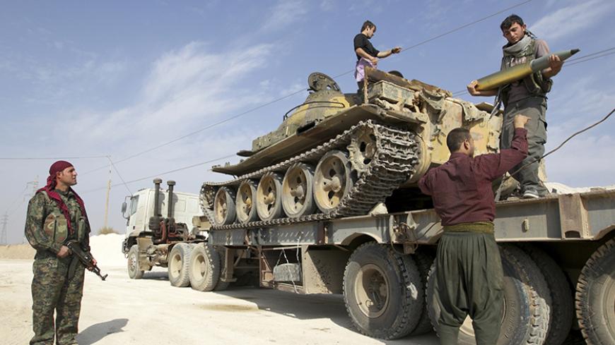 Members of Kurdish People's Protection Units (YPG) are seen on a military truck that belonged to the Islamist rebels after capturing it near Ras al-Ain, in the province of Hasakah November 6, 2013. Redur Xelil, spokesman for the armed wing of the Syrian Kurdish Democratic Union Party (PYD), said Kurdish militias had seized the city of Ras al-Ain and all its surrounding villages. Syrian Kurdish fighters have captured more territory from Islamist rebels in northeastern Syria, a Kurdish militant group said on 