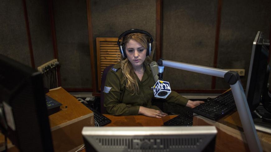 An Israeli soldier from Galei Tzahal, the Israeli army radio station, speaks during a broadcast session at the station's studio in Jaffa, south of central Tel Aviv November 10, 2013. The Israeli military operates two radio stations, a news-based station that started broadcasting in 1950, and Galgalatz, a popular music station marking its 20th anniversary. The stations mostly employ soldiers who work alongside civilian presenters, including leading names in Israeli broadcasting. Picture taken November 10, 20