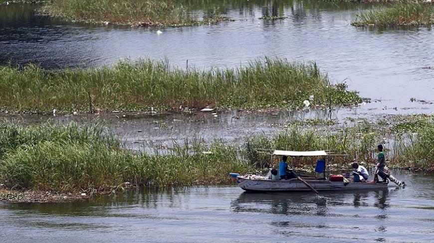 A fisherman travels on a boat during low tide on the river Nile in Cairo, Egypt June 5, 2015. REUTERS/Amr Abdallah Dalsh - RTX1FAVD
