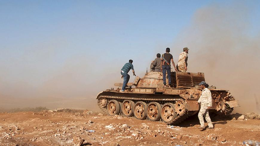 Members of the Libyan pro-government forces stand on a tank during their deployment in the Lamluda area, southwest of the city of Derna, Libya, June 16, 2015. Picture taken June 16, 2015. REUTERS/Stringer - RTX1GY57
