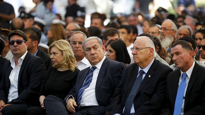 Israel's Prime Minister Benjamin Netanyahu (C) and his wife Sara (2nd R) sit next to President Reuven Rivlin (2nd L) during a ceremony on Mount Herzl in Jerusalem commemorating soldiers who died in the 2014 Gaza war July 6, 2015. The ceremony marked the first anniversary of Israel launching "Operation Protective Edge" in response to rockets fired by militants from the Hamas-ruled Gaza Strip.   REUTERS/Ronen Zvulun  - RTX1J9ZU
