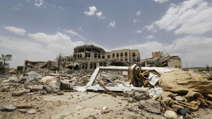 A part of a window frame is seen in front of government compound, destroyed by recent Saudi-led air strikes, in Yemen's northwestern city of Amran July 27, 2015. Yemen's Houthi group carried on fighting across Yemen on Monday despite a ceasefire announcement by its Saudi-led foes, and media controlled by the Iran-allied movement acknowledged that its forces had shelled targets inside Saudi Arabia. REUTERS/Khaled Abdullah - RTX1LZDB