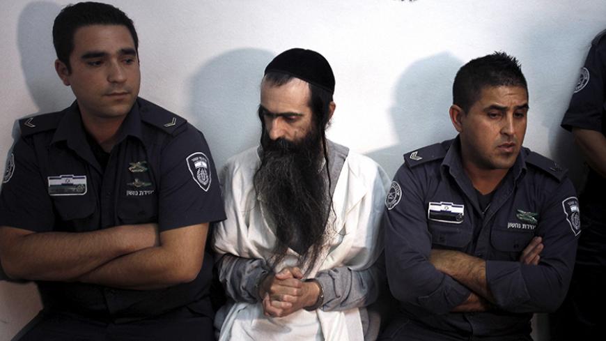 Yishai Schlissel (C) is escorted by security personnel at the Jerusalem Magistrates Court July 31, 2015. Schlissel is suspected of stabbing and wounding six participants at a Gay Pride parade in Jerusalem on Thursday.  REUTERS/Muammar Awad - RTX1MITX