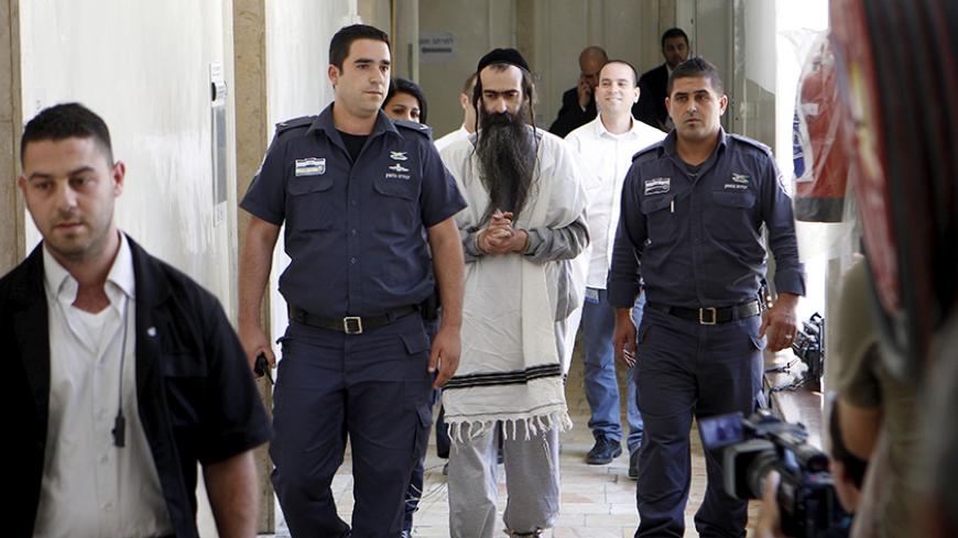 Yishai Schlissel is escorted by security personnel at the Jerusalem Magistrates Court July 31, 2015. Schlissel is suspected of stabbing and wounding six participants at a Gay Pride parade in Jerusalem on Thursday.  REUTERS/Muammar Awad - RTX1MITZ