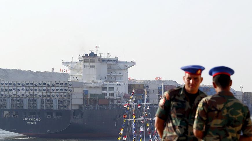 Egyptian Republican Guard stand guard, as a cargo container ship crosses the new section of the Suez Canal after the opening ceremony of the new Suez Canal, in Ismailia, Egypt, August 6, 2015. Egypt staged a show of international support on Thursday as it inaugurated a major extension of the Suez Canal which President Abdel Fattah al-Sisi hopes will power an economic turnaround in the Arab world's most populous country. REUTERS/Amr Abdallah Dalsh REUTERS/Amr Abdallah Dalsh - RTX1NCNP