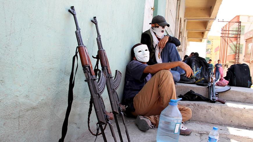 Masked members of YDG-H, youth wing of the outlawed Kurdistan Workers Party (PKK), sit next to their weapons in Silvan, near the southeastern city of Diyarbakir, Turkey, August 17, 2015. The PKK has attacked military targets on a near-daily basis since the Turkish government launched air strikes on rebel camps in northern Iraq on July 25, wrecking a two-year-old ceasefire. REUTERS/Sertac Kayar      TPX IMAGES OF THE DAY      - RTX1OICG