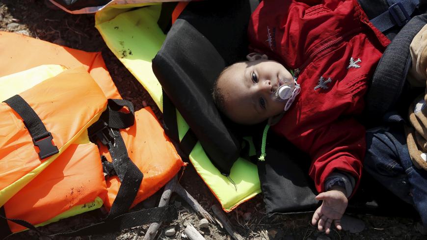 A baby from Syria lies on lifejackets moments after Syrian refugees arriving on a dinghy on the island of Lesbos, Greece, August 23, 2015. Greece, mired in its worst economic crisis in generations, has been found largely unprepared for a mass influx of refugees, mainly Syrians. Arrivals have exceeded 160,000 this year, three times as high as in 2014. The crisis has exposed massive shortages in Greece's available facilities, but also striking discord within the European Union on how to handle the humanitaria
