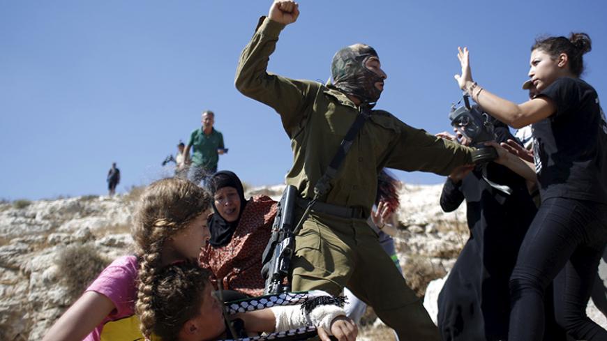 Palestinians scuffle with an Israeli soldier as they try to prevent him from detaining a boy during a protest against Jewish settlements in the West Bank village of Nabi Saleh, near Ramallah August 28, 2015. REUTERS/Mohamad Torokman - RTX1Q2IV