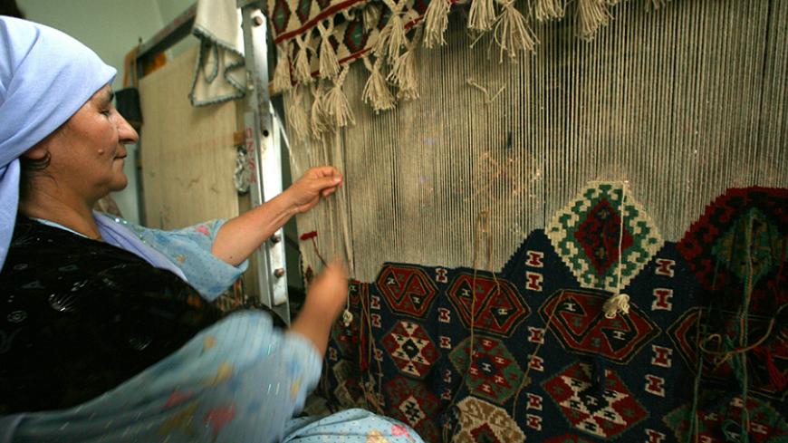 - PHOTO TAKEN 29NOV05 - A woman weaves a kilim carpet as a way to contribute to the household income in a workshop in Hakkari province, the most remote southeast province in Turkey, November 29, 2005. [In the shadows of mountains bordering Iraq and Iran, Turkey's Hakkari province may one day be an outpost of the European Union. But for now, it feels cut off from the world. Picture taken November 29, 2005.] - RTXO1TP