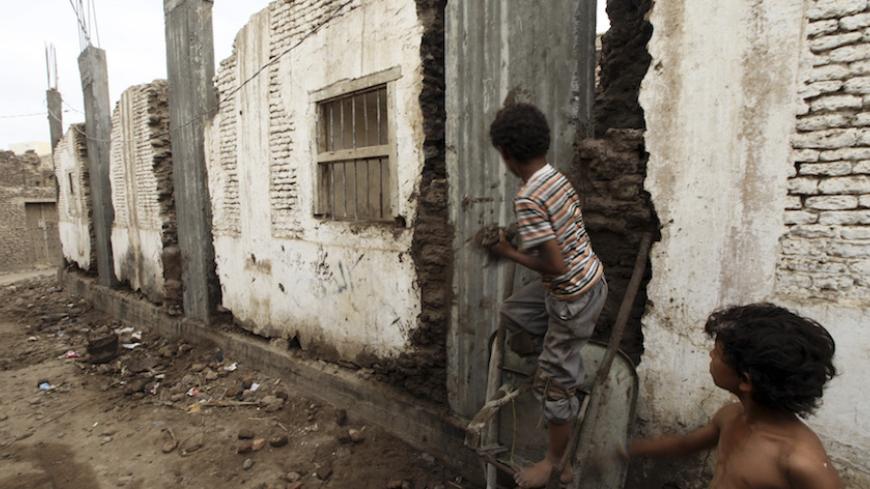 Boys are pictured on the side of a damaged house in the historical city of Zabid in the Yemeni province of Hodeidah May 15, 2013. The United Nations Educational, Scientific and Cultural Organisation (UNESCO) is threatening to remove the old city of Zabid, 25km (16 miles) on the road linking the port of Hodeidah to the city of Taiz, from the list of the world's protected heritage sites if the authorities do not stop the destruction of old buildings in favour of new cement ones.     REUTERS/Mohamed al-Sayaghi