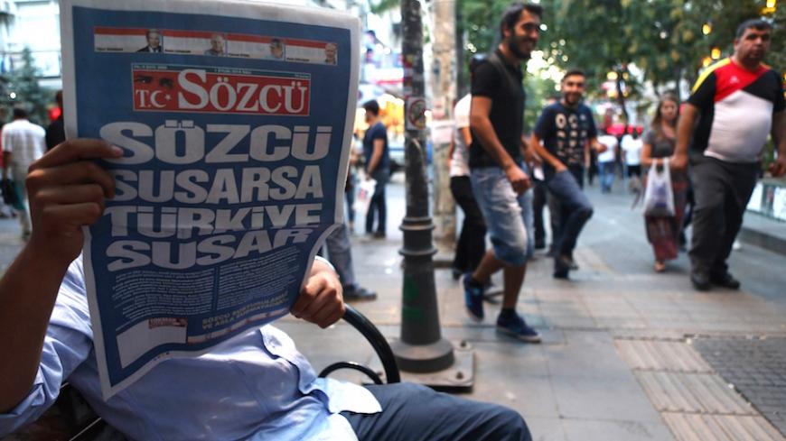 A man looks at the front page of Turkish daily newspaper Sozcu, which reads 'If Sozcu is silent, Turkey will be silent', on September 1, 2015 in Ankara. Sozcu, an opposition daily critical of the government, left the slots for opinion columns on its front page empty to protest against the governments 'increasing pressure'. Sozcu is accusing President Tayyip Erdogan and the Justice and Development Party (AKP) of 'increasing pressure over the past year on opposition newspapers'. AFP PHOTO/ADEM ALTAN        (P