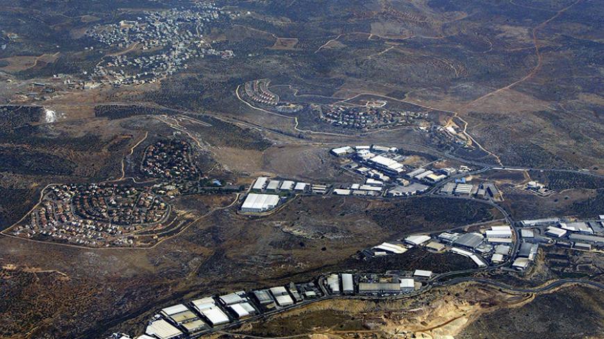 BARKAN, WEST BANK - JULY 30: The Israeli settlements of Barkan (left) and Kiryat Netafim (center) separate the Palestinian village of khirbet Bani Hassan (top left) July 30, 2004 from the of the West Bank settlement industrial area of Barkan (below). According to the left-wing Israeli movement Peace Now, some 230,000 Israelis live in 145 settlements in the West Bank and Gaza Strip, not including the scores of illegal outposts which Israel had promised the United States it would dismantle. (Photo by David Si