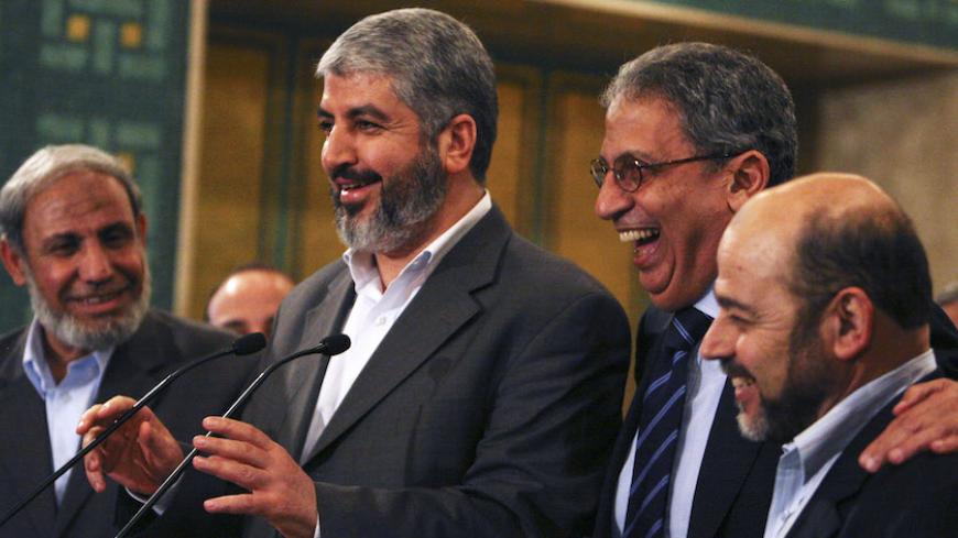 Hamas leader Khaled Meshaal (2nd L) and  Arab League Secretary-General Amr Moussa (2nd R) laugh during a news conference with Hamas senior leaders Mahmoud al-Zahar (L) and Moussa Abu Marzouk at the Arab League headquarters in Cairo June 9, 2009. REUTERS/Asmaa Waguih (EGYPT POLITICS) - RTR24HH4