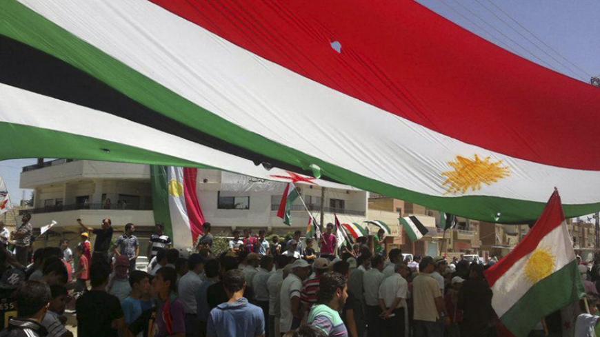 Demonstrators hold Kurdish and Syrian opposition flags during a protest against Syrian President Bashar al-Assad in  Hasakah July 6, 2012.  Picture taken July 6, 2012.  REUTERS/Shaam News Network/Handout (SYRIA - Tags: POLITICS CIVIL UNREST) FOR EDITORIAL USE ONLY. NOT FOR SALE FOR MARKETING OR ADVERTISING CAMPAIGNS. THIS IMAGE HAS BEEN SUPPLIED BY A THIRD PARTY. IT IS DISTRIBUTED, EXACTLY AS RECEIVED BY REUTERS, AS A SERVICE TO CLIENTS - RTR34QNS
