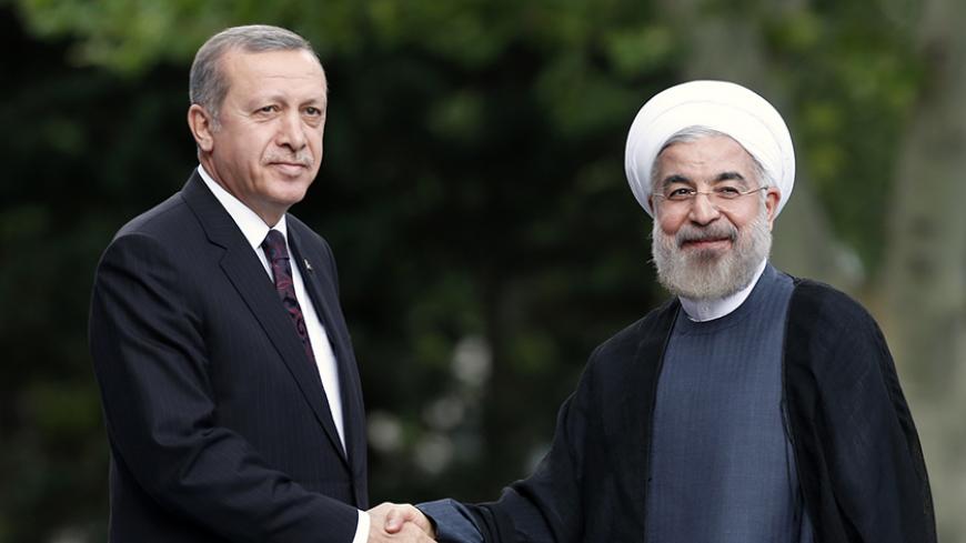 Iran's President Hassan Rouhani (R) is welcomed by Turkey's Prime Minister Tayyip Erdogan as he arrives for a meeting at Erdogan's office in Ankara June 9, 2014. REUTERS/Umit Bektas (TURKEY - Tags: POLITICS) - RTR3SVX6