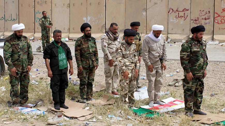 Shiite clerics from Hashid Shaabi (Popular Mobilisation) forces, allied with Iraqi forces against the Islamic State, pray in Tikrit March 28, 2015.  Four Iraqi soldiers were killed in street fighting with Islamic State militants in Tikrit overnight as they advanced slowly into the city, a Sunni jihadist bastion, in the wake of coalition air strikes, a security official said.   REUTERS/Thaier Al-Sudani - RTR4V9FA