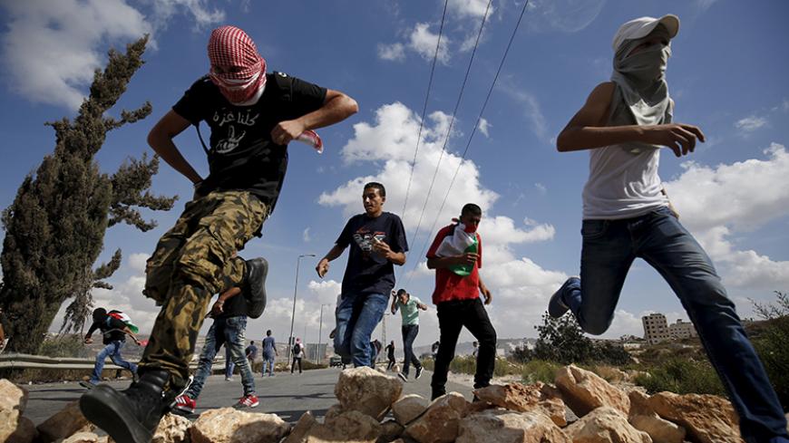 Palestinian protesters run during clashes with Israeli troops over tension in Jerusalem's al-Aqsa mosque, near the occupied West Bank city of Ramallah September 29, 2015. Israeli police and Palestinians clashed on Sunday at Jerusalem's al-Aqsa mosque compound, where violence in recent weeks has raised international concern. REUTERS/Mohamad Torokman      TPX IMAGES OF THE DAY      - RTS29AG