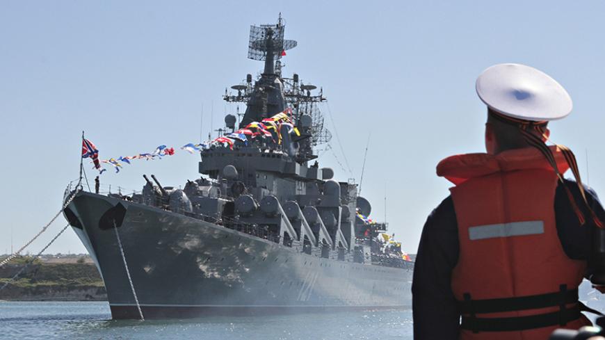A sailor looks at the Russian missile cruiser Moskva moored in the Ukrainian Black Sea port of Sevastopol in this May 10, 2013 file photo. Russia is sending two warships to the east Mediterranean, Interfax news agency said on August 29, 2013, but Moscow denied this meant it was beefing up its naval force there as Western powers prepare for military action against Syria. Picture taken May 10, 2013. REUTERS/Stringer (UKRAINE - Tags: MILITARY POLITICS MARITIME CONFLICT) - RTX130BI