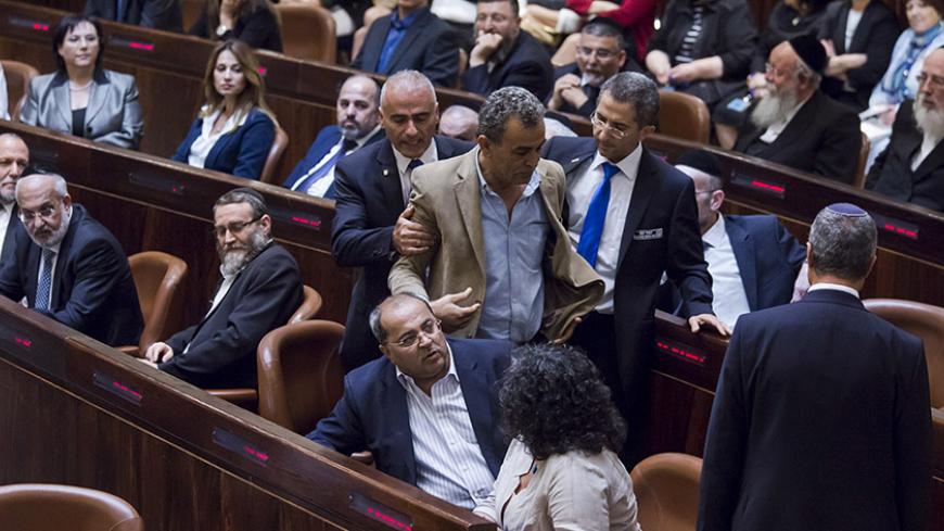 Jamal Zahalka (C), an Israeli-Arab lawmaker from the Joint Arab List, is taken out of the Knesset, the Israeli parliament, during Israeli Prime Minister Benjamin Netanyahu's speech as he presents his new coalition government following the mid-March general elections, in Jerusalem May 14, 2015. Netanyahu's new rightist coalition government, hobbled from the outset by its razor-thin parliamentary majority, was sworn in late on Thursday amid wrangling within his Likud party over cabinet posts. REUETRS/Jim Holl