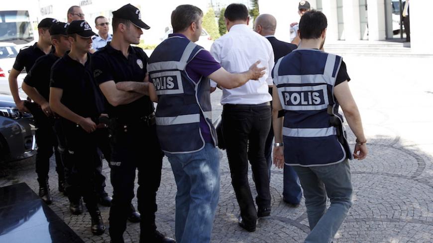 Police officers frisk an employee of the Koza Ipek Group during a raid at the company's office in Ankara, Turkey, September 1, 2015. Turkish police raided the offices of the conglomerate with close links to U.S.-based Muslim cleric Fethullah Gulen, an ally-turned-foe of President Tayyip Erdogan, company officials said on Tuesday.  REUTERS/Umit Bektas  - RTX1QKD8