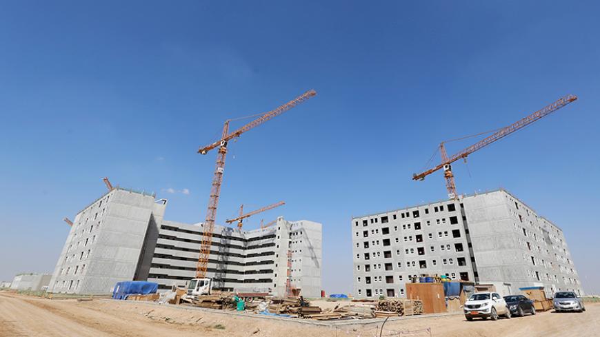 A general view of the buildings at Bismayah residential project in Baghdad, February 26, 2015. On a main highway south of Baghdad, dozens of buildings rise up from the Iraqi plains, the first blocks of a multi-billion-dollar city emerging from a landscape more accustomed to conflict and crisis than glitzy new development. Bismayah New City, which aims to house half a million people within four years, dwarfs any construction project Iraq has attempted in a generation. Picture taken February 26, 2015.  REUTER